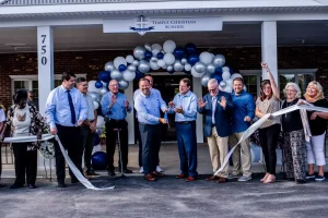 Temple Christian School officials cut the ribbon outside of the building