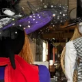 Two scarecrows are propped up inside an antique shop.