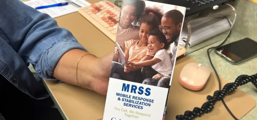 A person holds up an MRSS pamphlet