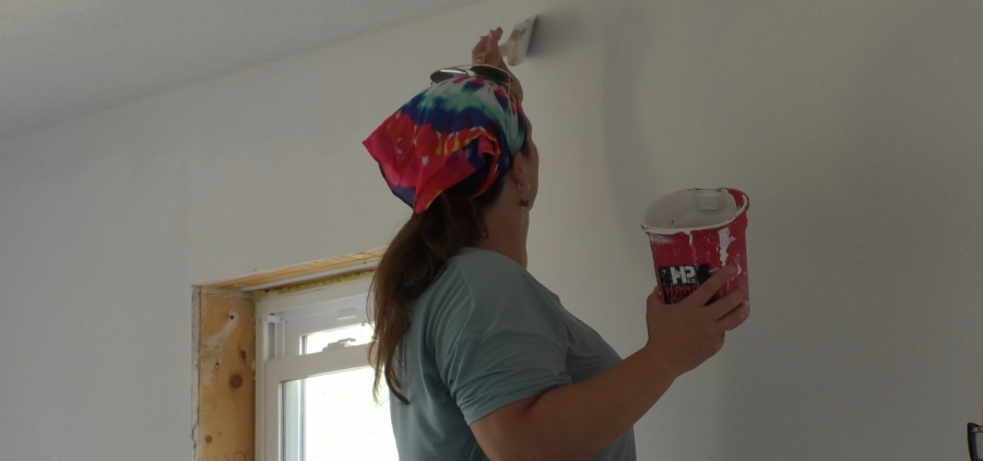 A Habitat for Humanity volunteer brushes primer onto the walls of an unfinished house in Glouster. Once the home is completely finished, it will be ready for the new homeowner to move in.