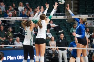 Kam Hunt (#23) and Elizabeth Hoerlein (#7) go for a block vs Buffalo. 