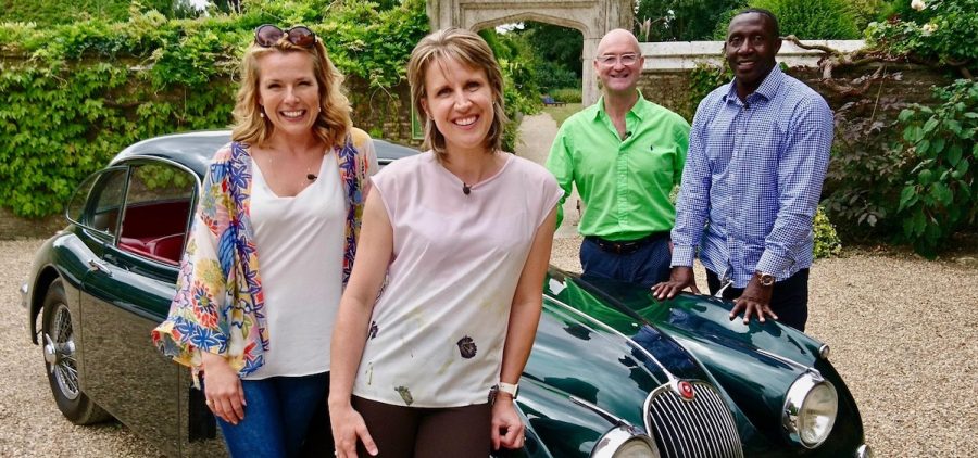 Olympic runners Linford Christie and Katharine Merry team up with Road Trip regulars in a race to make the most money from antiques. Standing in front of vintage UK auto.