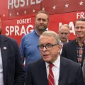 Gov. Mike DeWine (R-Ohio), incumbent running for re-election, speaks to reporters while joined by J.D. Vance, Republican candidate for U.S. Senate, and other Republican candidates for statewide office outside their tour bus.