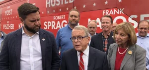 Gov. Mike DeWine (R-Ohio), incumbent running for re-election, speaks to reporters while joined by J.D. Vance, Republican candidate for U.S. Senate, and other Republican candidates for statewide office outside their tour bus.