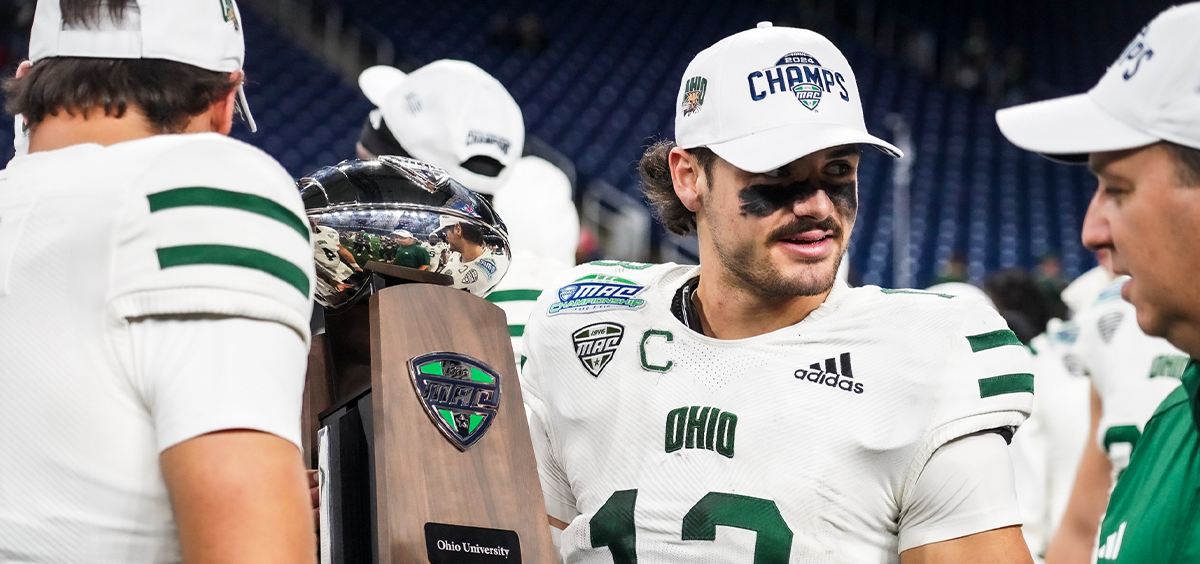 Parker Navarro holding the MAC Championship trophy after taking down Miami 38-3.