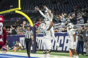 Parker Navarro (#13) being lifted up after scoring a rushing TD. 