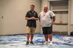 Brian Smith (left) and Rob Smith (right) talking at the Cure Bowl Charity event. 