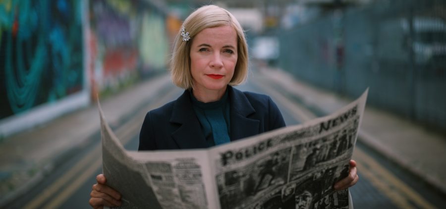 Lucy Worsley reading a Jack the Ripper newspaper story in Whitechapel, the location of the Ripper’s killings. Credit: Tom Hayward, BBC Studios