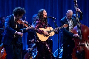 Sara Bareilles: New Year's Eve with the National Symphony Orchestra & Friends. Sara in middle with violin and stand up bass on either side.