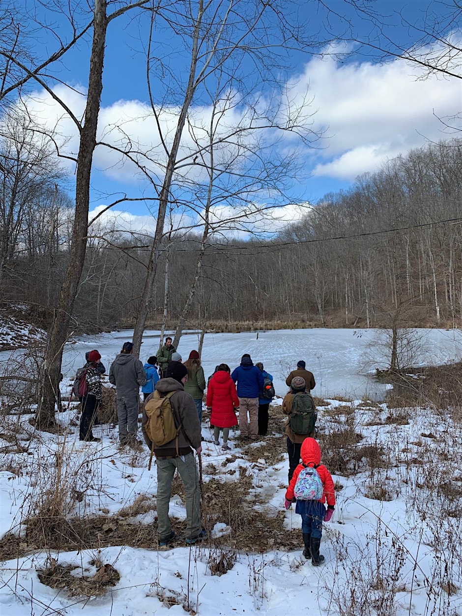 An image of people walking in the snowy woods.