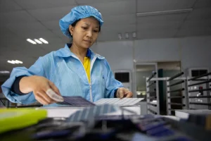 A factory worker sorts solar cells at Red Sun Energy’s manufacturing plant