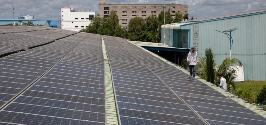 Workers repair gutters on the roof of Red Sun Energy’s manufacturing factory outside Ho Chi Minh City, Vietnam