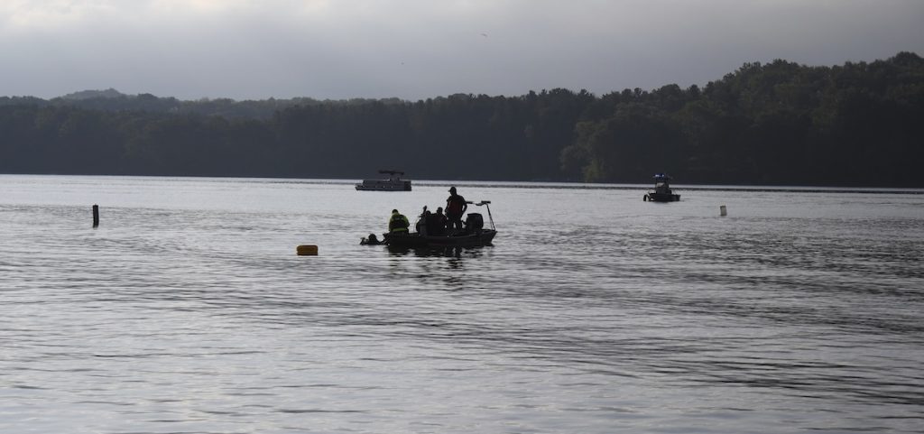 Members of a dive team on Atwood Lake float over a spot where they recovered a body.