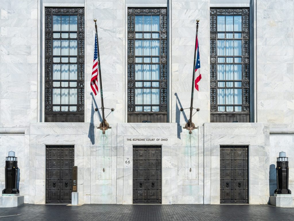 White marble entrance to the Supreme Court of Ohio in Columbus with US flag flying