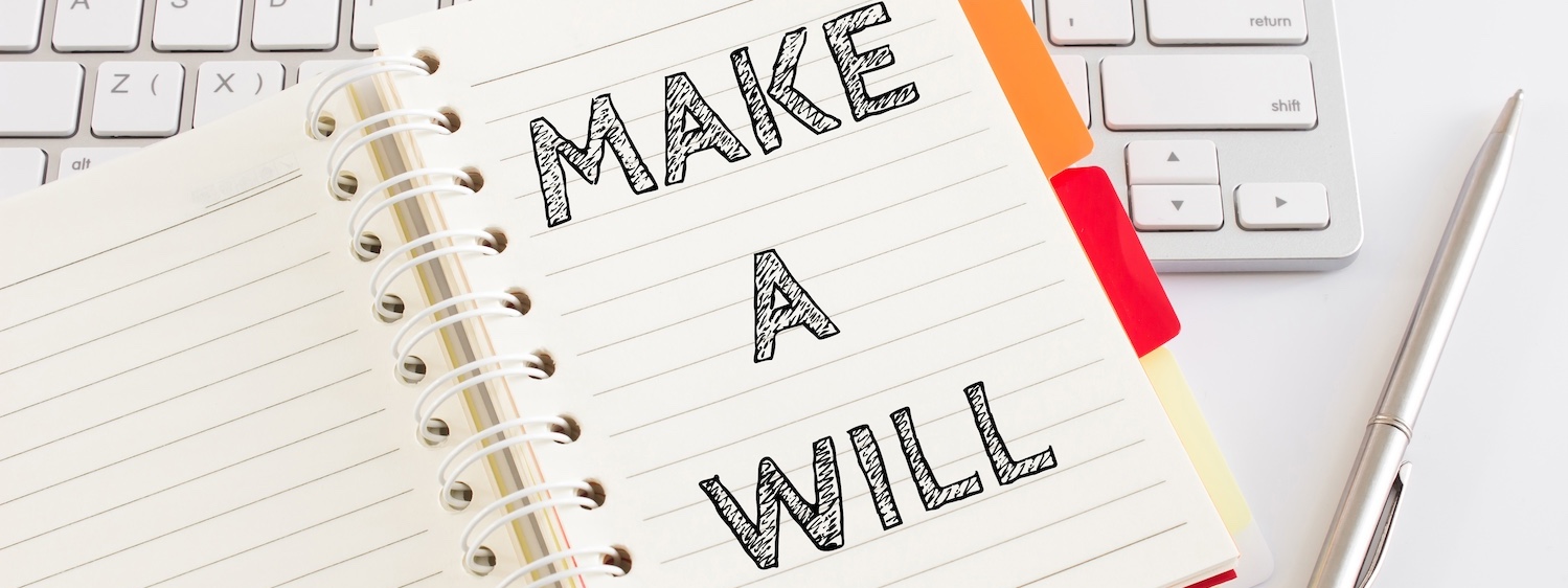 Text "Make a will" on white lined paper on office table and keyboard