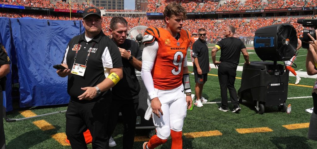 Cincinnati Bengals quarterback Joe Burrow, center, is exits the medical tent for the locker room after suffering an injury during the second quarter of an NFL football game