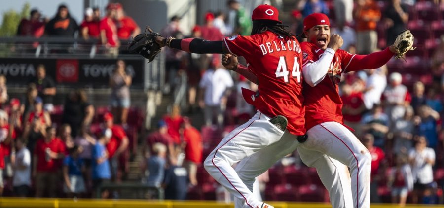 Cincinnati Reds shortstop Elly De La Cruz (44) and outfielder Noelvi Marte (16) bump shoulders in the air.