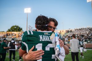 Ohio Football starring quarterback Parker Navarro and head coach Brian Smith hugging after the Bobcats 17-10 win over West Virginia.