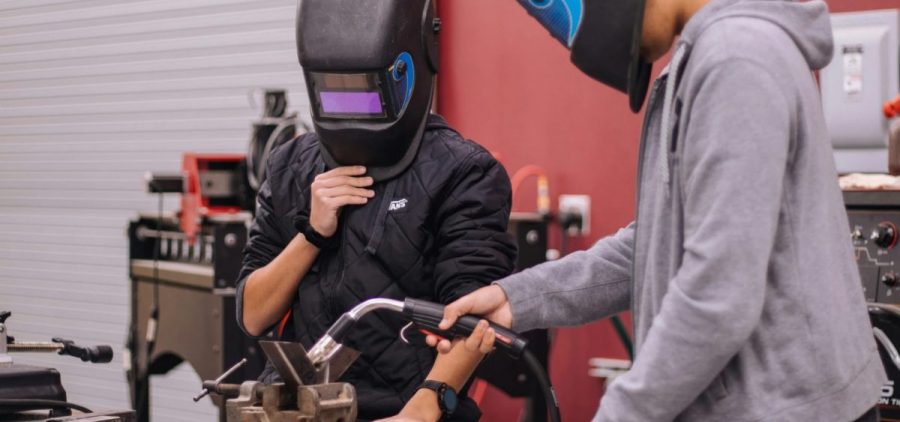 Two students work on a welding project.