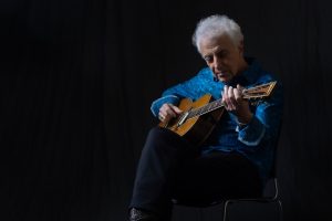 A press image of musician Doug MacLeod, playing guitar.