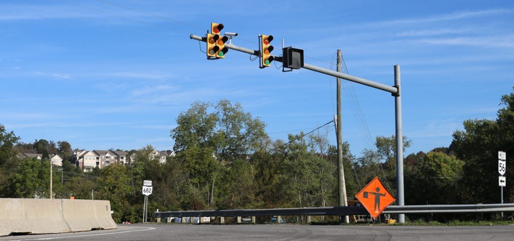 A traffic light and road work signage at the intersection of state routes 682 and 56.