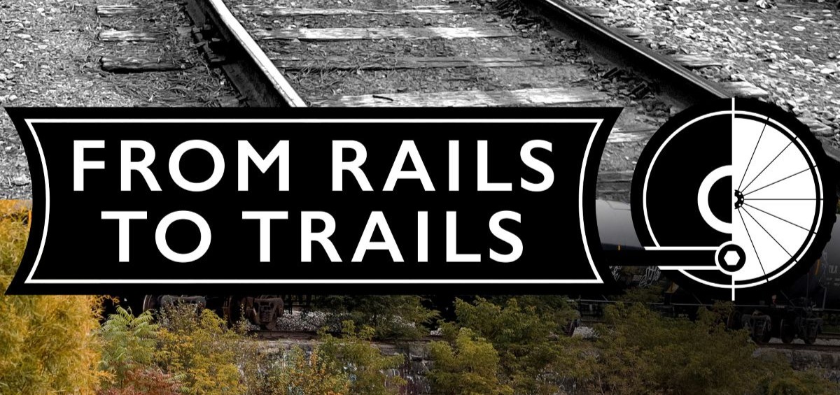 Text reading FROM RAILS TO TRAILS displayed in the center. A black and white picture of a train track if displayed behind the text on the upper part of the photo, a color picture of the train tracks with the train running in pictures on the bottom half of the photo.
