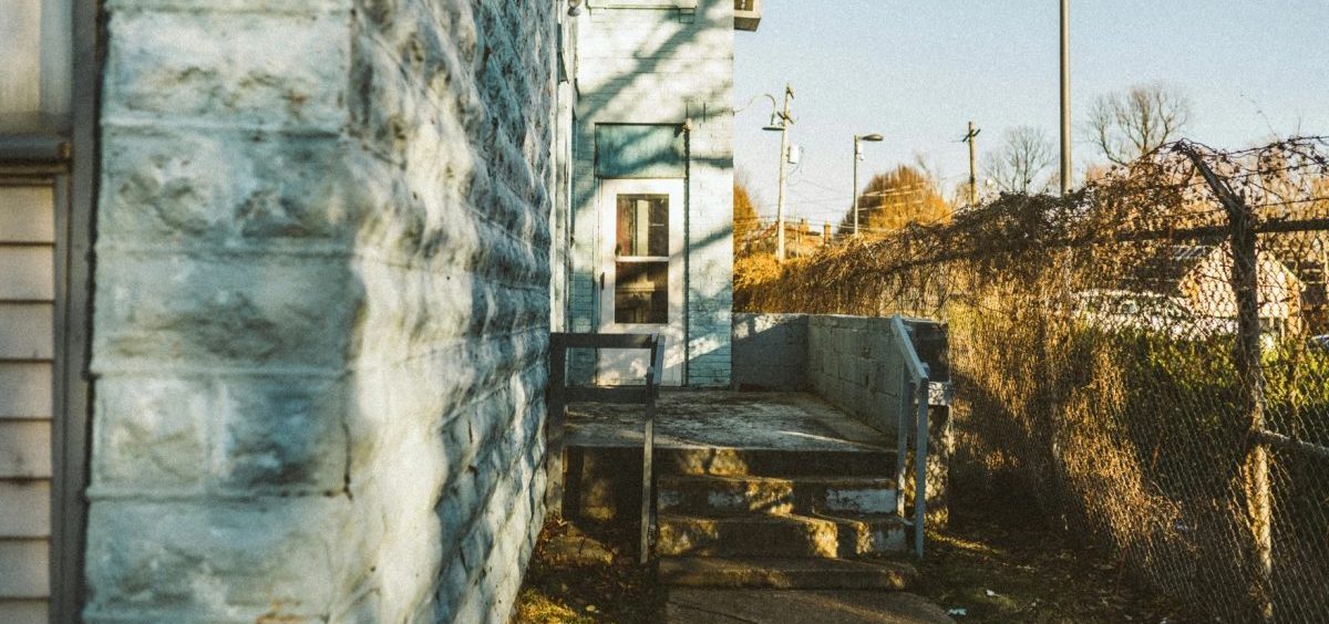 A multi family housing unit as seen down an alley.