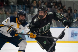 Ohio Hockey forward Hollander Thompson battling for a puck against Kent State.
