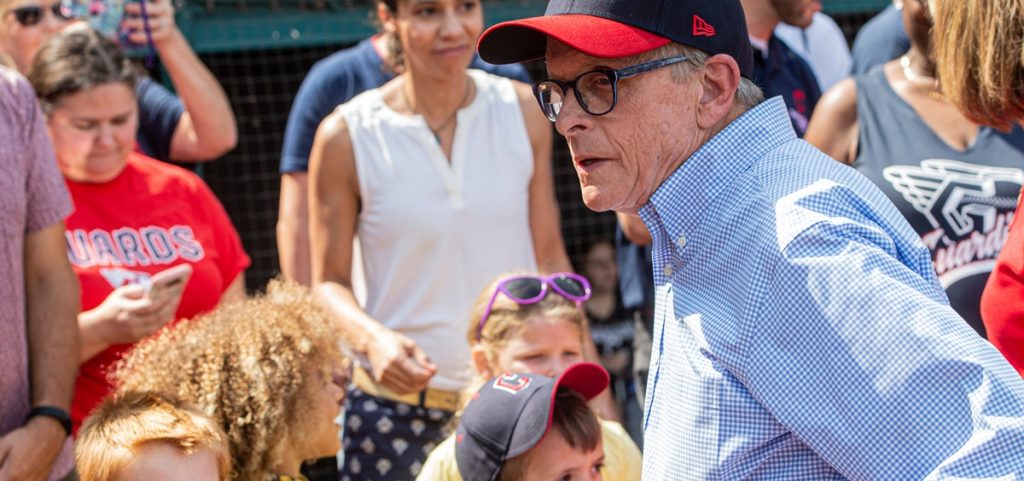 Ohio Gov. Mike DeWine, right, waits to hand out reading certificates to children before a Cleveland Guardians baseball game against the Minnesota Twins in Cleveland,