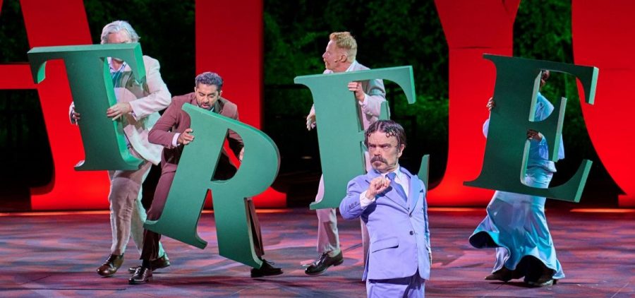 Peter Dinklage and cast members in GREAT PERFORMANCES "Twelfth Night." Four cast members hold large green letters that spell "TREE"