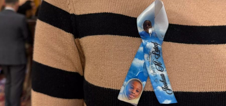 Jonisa Cook wears a ribbon in honor of her son Joshua Al-Lateef, Jr.