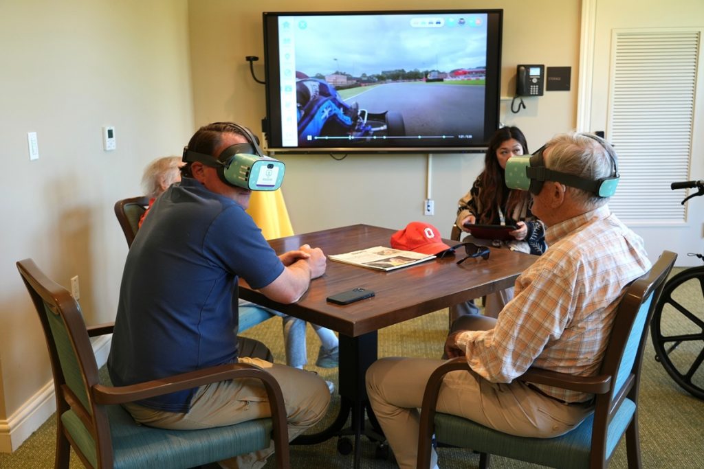 Mike Holtshouse and his father, Jim Holtshouse, watch video through Rendever virtual-reality headsets at the Forum at Rancho San Antonio retirement community