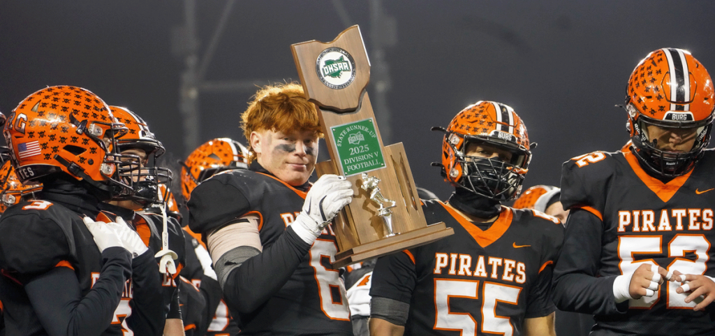 A wheelersburg player holds up the runner up trophy surrounded by teamates.