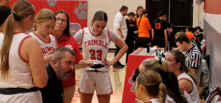 The Trimble girl's basketball team huddles around coach Josh Lavy during a timeout.