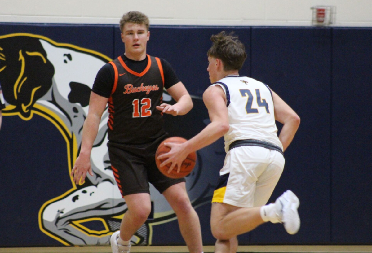 South Point player in white jersey dribbling the ball against Nelsonville York player in black jersey.