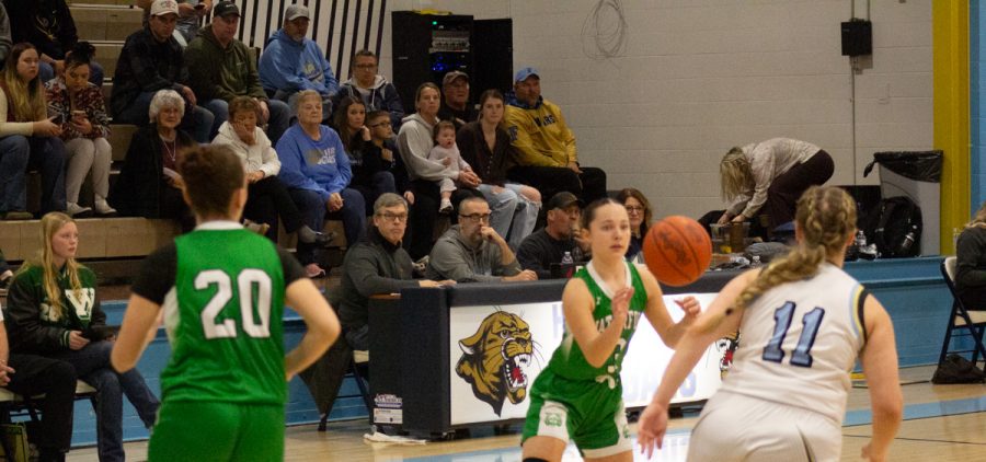 Elsi Malec reciving the ball and pushing up the court as two other players follow