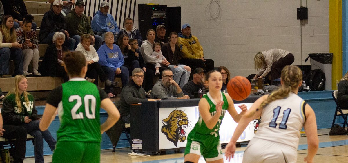 Elsi Malec reciving the ball and pushing up the court as two other players follow