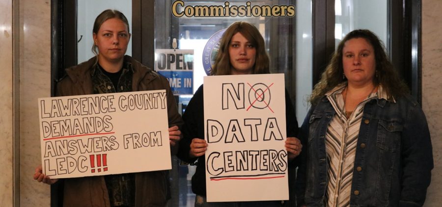 Danielle Fletcher, Katie Hill and another Lawrence County resident hold signs protesting data centers in Lawrence County.