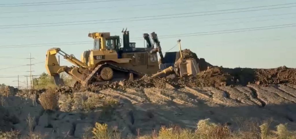 A bulldozer moves on a pile of dirt at the site of the new Browns' domed stadium in Brook Park