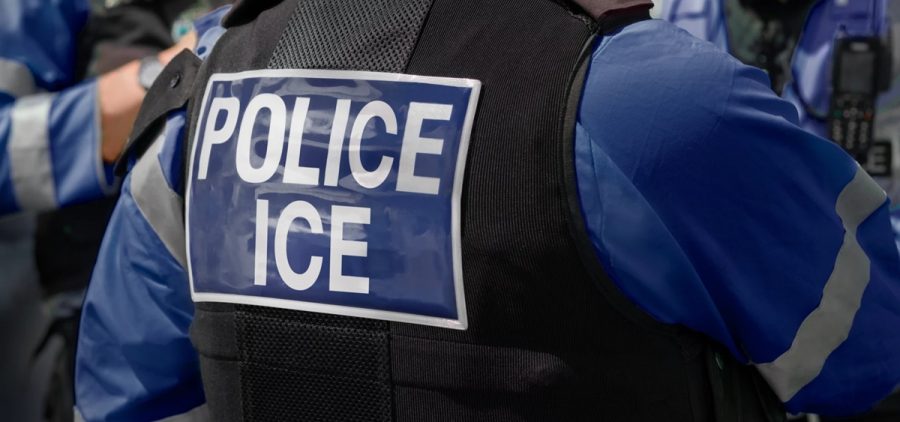 A person has a vest on that says Police ICE