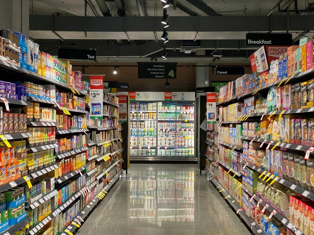 An isle is filled with groceries in a store.