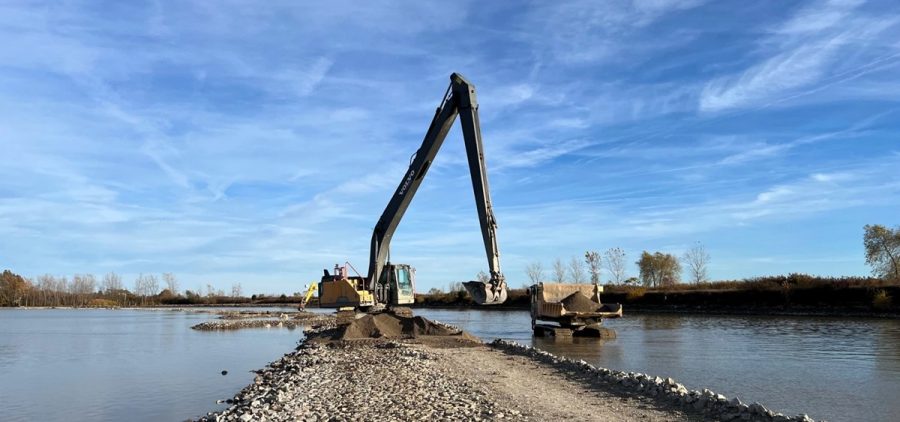 Large equipment builds a natural barrier in the Sandusky Bay out of rocks and dirt
