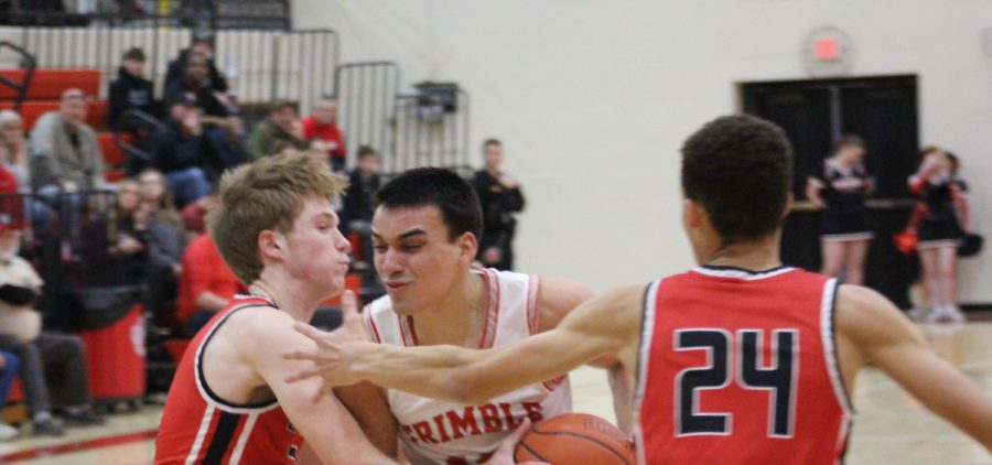 Brady Jajczyk fighting through two Alexander defenders on the way to the basket.