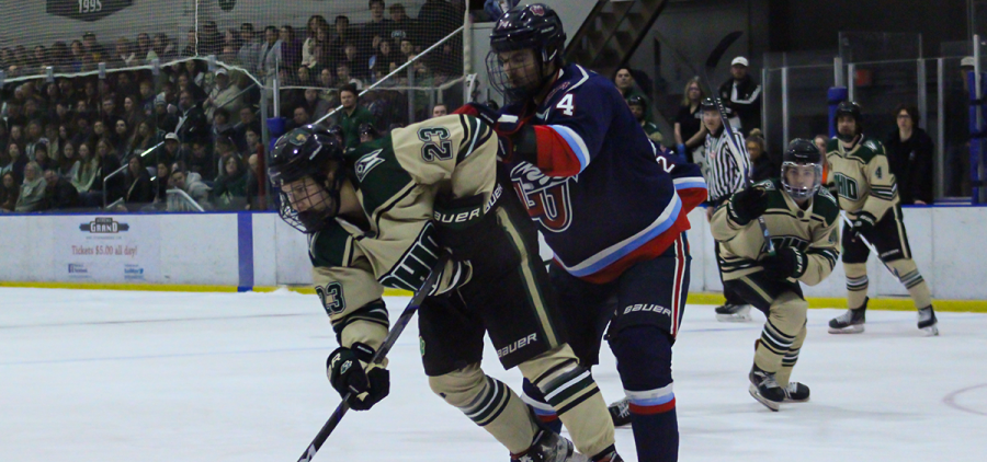 Ohio Hockey forward Nolan Abraham being pushed by a Liberty defender.