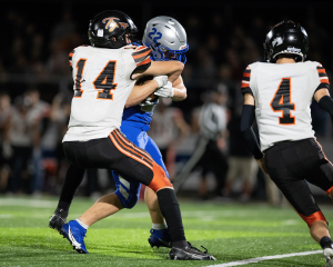 A Warren Warriors player attempts to break a tackle by a Marietta Tiger defender