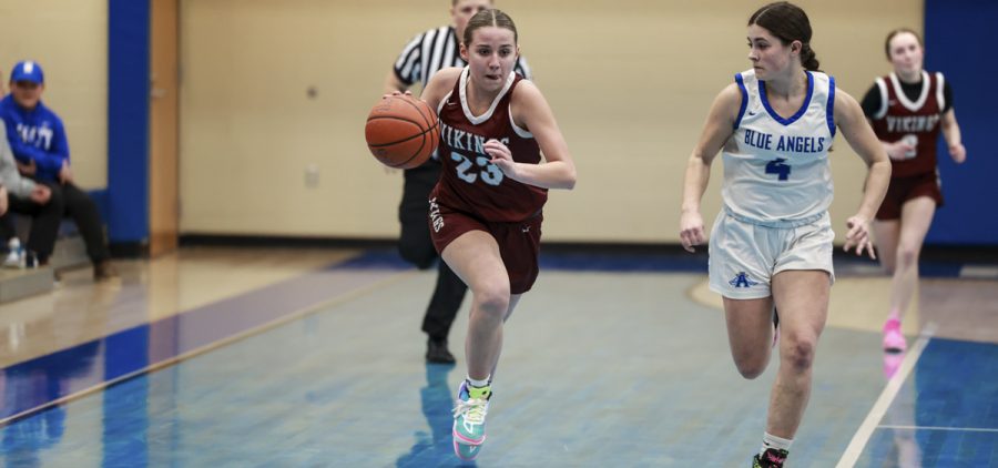 Alissa Perry runs the ball up the court, trying to get past her Blue Angel defender.