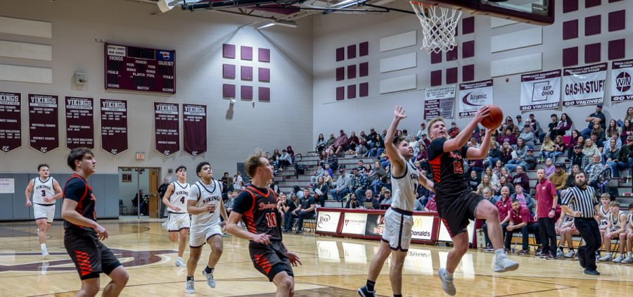 Cam Sullivan goes yup for a layup with a Vinton County defender right on his trail.