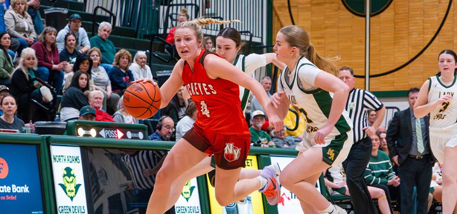 Madi Pidcock drives the ball up the court with a North Adam's defender right on her trail.