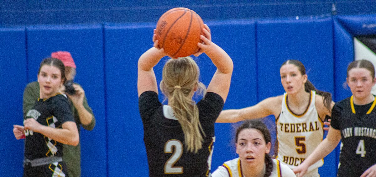 The Lady Mustang looks to pass while being guarded by Takira Walker.