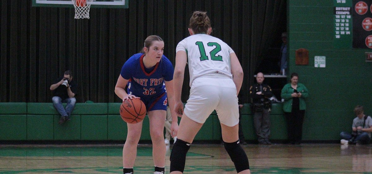 The Fort Frye Cadet looks to pass to a teammate with a Waterford player guarding her, looking to deny the pass.